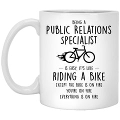 Funny Being A Public Relations Specialist Is Easy It's Like Riding A Bike Except Coffee Mug 11oz White XP8434